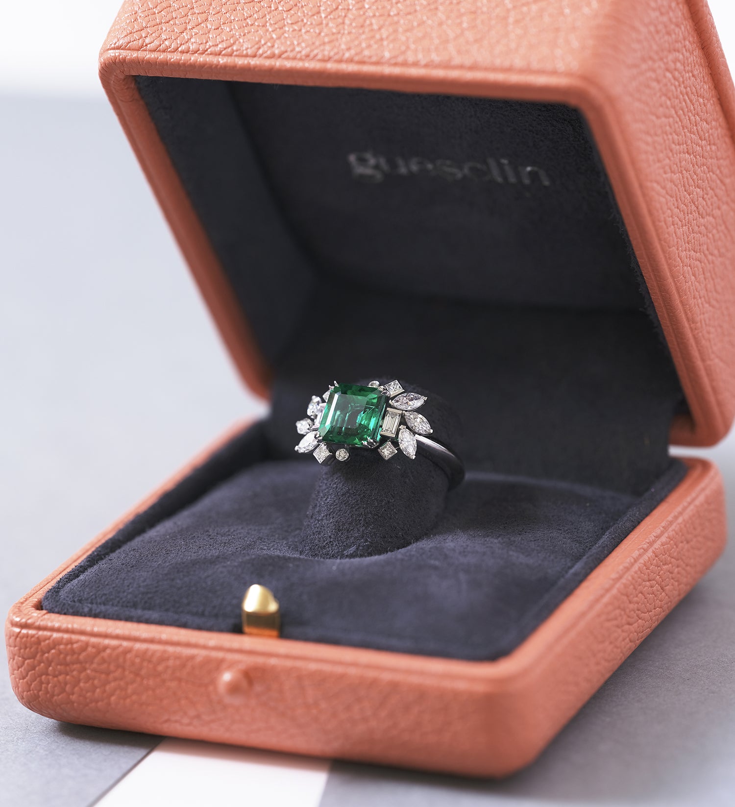 Bague de fiançailles sur-mesure Guesclin avec une émeraude et des diamants dans son écrin